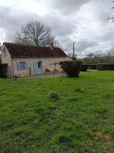 ein Haus auf einem Feld mit einem Rasenplatz in der Unterkunft La petite maison en Puisaye in Dampierre-sous-Bouhy