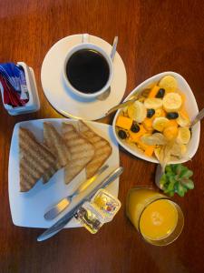 una mesa con dos platos de comida y una taza de café en El Chasqui, en Ollantaytambo