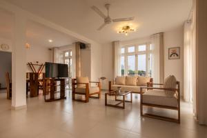 sala de estar con muebles y TV de pantalla plana. en Glowing Crescent en Rajagiriya