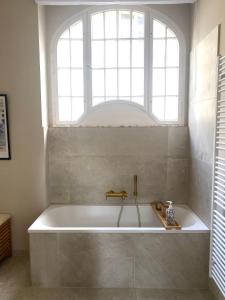 uma banheira na casa de banho com uma janela em Luxus Apartment, UEFA Olympiastadion, Messe ICC em Berlim