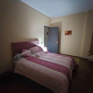 um quarto com uma cama grande e lençóis cor-de-rosa em Two pools four bedrooms private villa em Qaryat Shākūsh