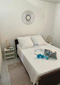 a bed with white sheets and blue scissors on it at LAKAY SONSON in Les Anses-dʼArlets