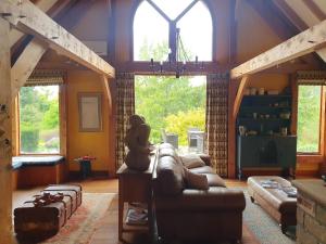 a living room with a couch and two windows at Streamside Country Manor- Matamata in Matamata +59 photos