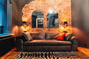 a brown couch in a room with a brick wall at EASY RENT Apartments - Litewski Styl, Centrum 24h Check-in in Lublin +11 photos