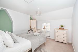Dormitorio pequeño con cama y vestidor en Puddle Duck Cottage en Cranswick