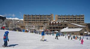 a group of people skiing down a snow covered slope at Beaver Run Resort in Breckenridge