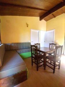 - une chambre avec une table, des chaises et un canapé dans l'établissement CAMPING-BUNGALOWS-CABAÑAS LA VERA, à Jarandilla de la Vera