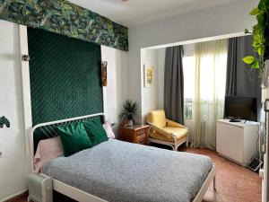 een slaapkamer met een bed, een stoel en een televisie bij Habitaciónes La JUNGLA 22 in Algeciras