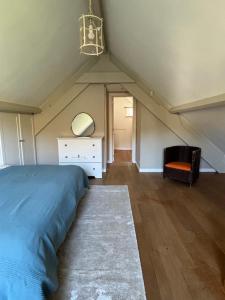 ein Schlafzimmer mit einem Bett, einer Kommode und einem Stuhl in der Unterkunft Duplex Rosières - 12’ de Bruxelles in Rixensart