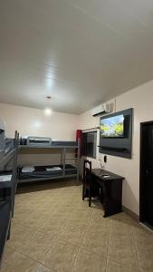 a room with a bed and a desk and a tv at Hotel Val-de-Cans Aeroporto in Belém