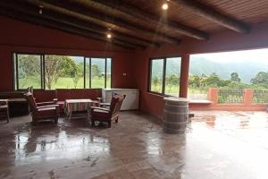 a large room with a table and chairs and windows at finca de barcena, country house in Tumbaya