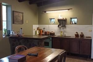 a kitchen with a wooden table and a counter top at finca de barcena, country house in Tumbaya
