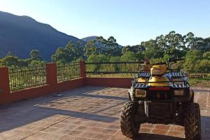 a yellow atv parked on a patio with mountains in the background at finca de barcena, country house in Tumbaya