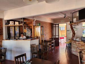 a woman sitting at a bar in a restaurant at Hostería Montes in San Ignacio