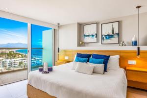een slaapkamer met een groot bed met blauwe en witte kussens bij Ocean Vista Oasis at Maritima Playa in Bucerías