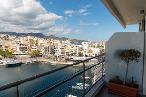 uma varanda com vista para uma cidade e um rio em Remvi apartments em Agios Nikolaos
