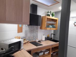 a kitchen with a wooden table with a microwave at La Casita del Pueblo in Candeleda