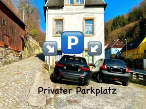 zwei Autos auf einem Parkplatz neben einem Haus geparkt in der Unterkunft Boutique Apartment • Zentrum • Netflix • Parkplatz in Bad Schandau