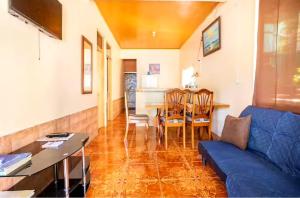 uma sala de estar com um sofá azul e uma mesa em Apartamentos Morpho CR 2 em Quepos