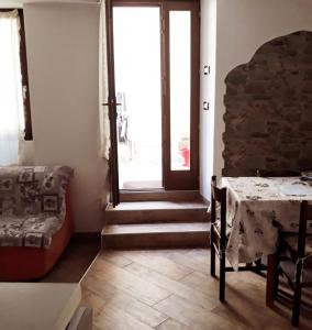 ein Wohnzimmer mit einem Tisch und einer Tür in der Unterkunft bbcascata in Bocenago