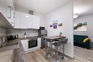 uma cozinha com armários brancos e uma mesa com bancos em Golden Cage Premium Central Apartment em Budapeste