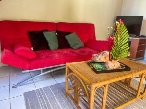 a living room with a red couch and a coffee table at Studio Jo'kmi in Pointe-Noire