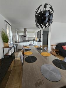 ein Esszimmer und eine Küche mit einem großen Holztisch in der Unterkunft La Maison Richard in Thizy-les-Bourgs