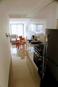 a kitchen with a stove and a living room at Flamingo Plateau 1A apt on Rua Pedonal Praia Cape Verde in Praia