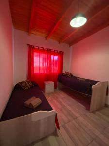 2 camas en una habitación con ventana roja en ALQUILER X DIA Merlina en Catriel