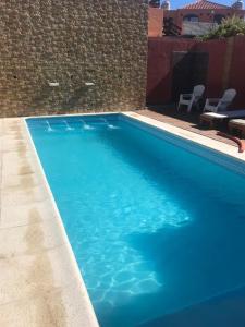 ラス・グルータスにあるMarina Azulのレンガの壁の横にある青い大型スイミングプール