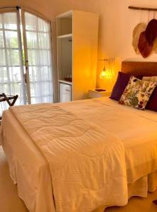 a bedroom with a large bed with a white bedspread at Bosque Toque Toque - Pousada B&B in São Sebastião