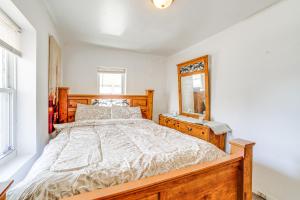 um quarto com uma cama de madeira e um espelho em Dog-Friendly Michigan City Home - 3 Mi to Beach! em Michigan City