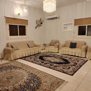 a living room with two couches and a rug at Khair Jewaar Apartments Al Madinah in Al Madinah