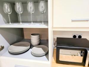 a cupboard with wine glasses and plates in it at Stay Sleep Rest - Heeley in Heeley