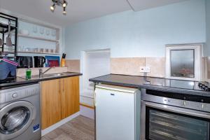 een keuken met een wasmachine en een vaatwasser bij Pass the Keys Cosy Haven In Glastonbury: One Bedroom Apartment in Glastonbury