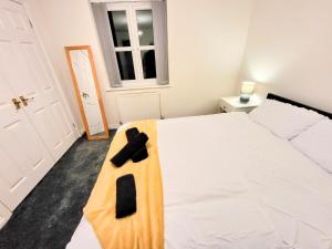 a bedroom with a white bed with a cross on it at Stay Sleep Rest - Heeley in Heeley