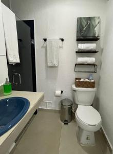 a bathroom with a toilet and a sink with towels at Departamento Cancún in Cancún