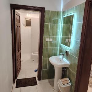 Khair Jewaar Apartments Al Madinah في المدينة المنورة: حمام مع حوض ومرحاض
