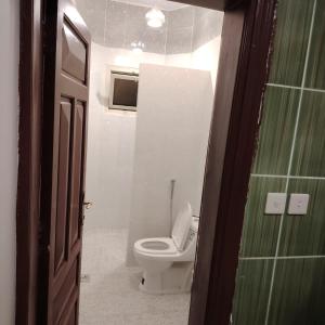 Khair Jewaar Apartments Al Madinah في المدينة المنورة: حمام مع مرحاض أبيض في الغرفة