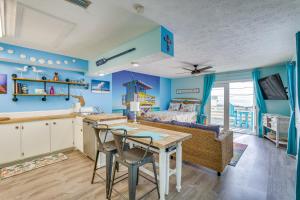 een keuken en een woonkamer met een tafel en stoelen bij Breezy PCB Apt with Balcony - Walk to Beach! in Panama City Beach
