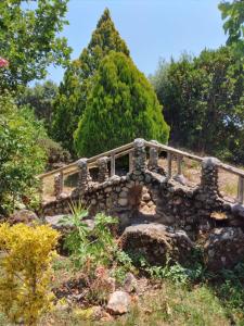 a stone bridge in the middle of a garden at CAMPING-BUNGALOWS-CABAÑAS LA VERA in Jarandilla de la Vera