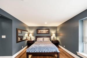 a bedroom with gray walls and a bed with two night stands at Plymouth Paradise in Plymouth