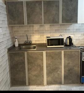 a kitchen counter with a microwave and a sink at شاليه قلب الهدا 3-4 in Al Hada