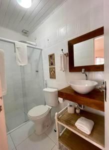 a bathroom with a toilet and a sink and a shower at Bosque Toque Toque - Pousada B&B in São Sebastião