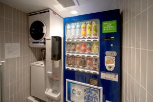 a vending machine in a bathroom with soda bottles at Hop Inn Tokyo Ueno in Tokyo