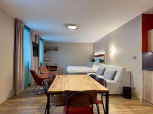 サン・ジャン・ド・モーリエンヌにあるBest Western Hotel Coeur de Maurienneのリビングルーム(ソファ、テーブル付)