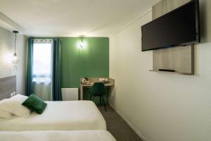 a hotel room with a bed and a desk at Sure Hotel by Bestwestern Rouvignies Valenciennes in Valenciennes