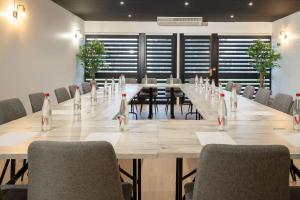 una gran sala de conferencias con una mesa larga y sillas en Sure Hotel by Bestwestern Rouvignies Valenciennes, en Valenciennes