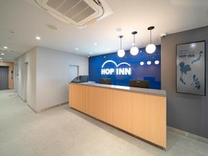 an office lobby with a top inn sign on the wall at Hop Inn Tokyo Ueno in Tokyo