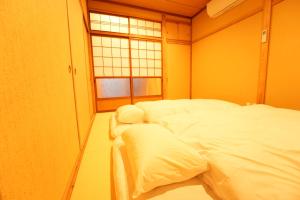 2 camas en una habitación con ventana en RIKKA BABA ICHI en Takayama